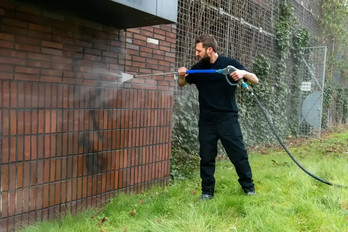 Graffiti en aanslag verwijderen van een bakstenen muur door Keyo